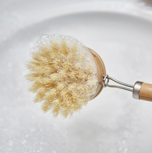 bamboo dish brush with handle covered with soap bubbles