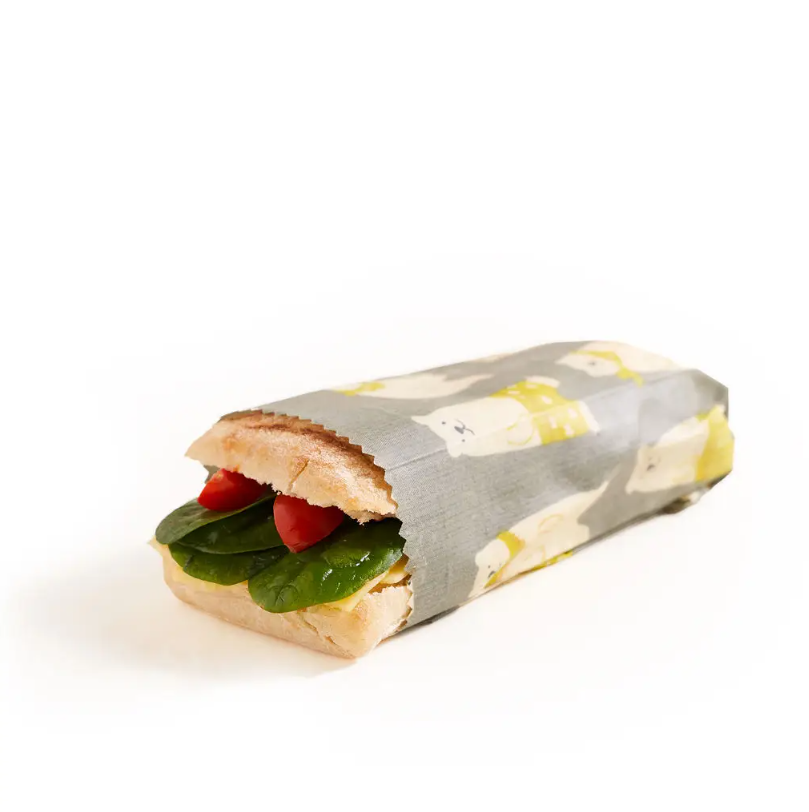 Beeswax food wraps with a sandwich wrapped inside of it
